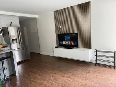a kitchen with a tv on a white entertainment center at Private two bedroom basement suite Sleeps six people in Surrey