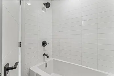 a white bathroom with a tub and a sink at Peak n Plunge Insane MTN View Pool n Hot Tub K201 in Canmore
