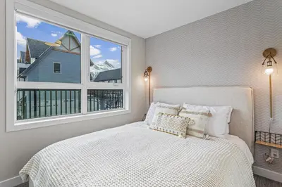 a bedroom with a bed and a large window at Peak n Plunge Insane MTN View Pool n Hot Tub K201 in Canmore