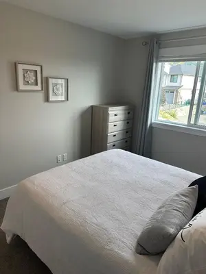 a bedroom with a white bed and a window at Modern One-Bedroom Retreat in Bear Mountain in Langford