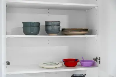 a shelf with bowls and plates on it at Classic 2 Bed-Basement Near the lake in Edmonton