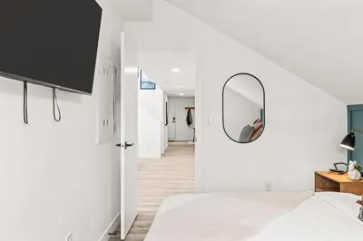 a bedroom with a bed and a mirror on the wall at 3BR Escape BBQ, Balcony, Near Banff & DT in Canmore