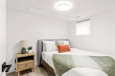 a white bedroom with a bed and a window at 3BR Escape BBQ, Balcony, Near Banff & DT in Canmore