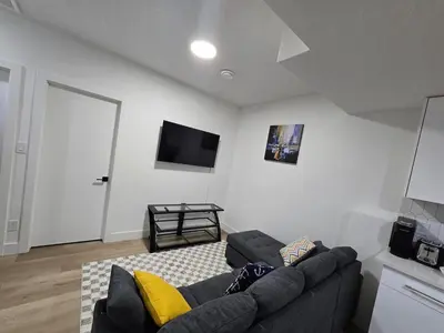a living room with a couch and a flat screen tv at Lush 1 Bedroom house with WiFi in Edmonton in Edmonton