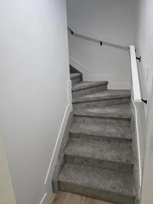 a staircase with grey carpet and white walls at Lush 1 Bedroom house with WiFi in Edmonton in Edmonton