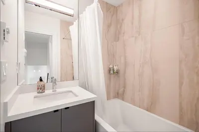 a white bathroom with a sink and a shower at Dunbar Brand-new laneway house in Vancouver