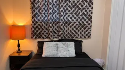 a bedroom with a bed with a black and white headboard at Calgary Super Cozy Guest Rooms Near Banff in Calgary