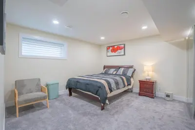 a bedroom with a bed and a chair at Anna Suite Rental in Edmonton