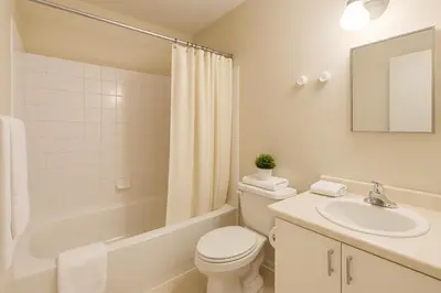 a white bathroom with a toilet and a sink at Bright Downtown Room Walk Everywhere Aurora Nearby in Whitehorse