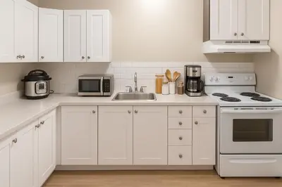 a white kitchen with a sink and a microwave at Bright Downtown Room Walk Everywhere Aurora Nearby in Whitehorse