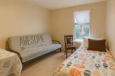 a bedroom with a bed and a couch and a window at Bright Downtown Room Walk Everywhere Aurora Nearby in Whitehorse