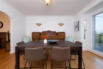 a dining room with a wooden table and chairs at Elegant Spanish Villa with Ocean & Mountain Views in Vancouver