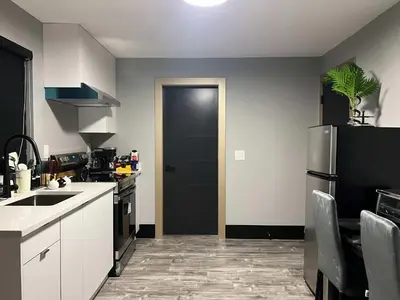 a kitchen with a refrigerator and a black door at Spacious 2-Bedroom Retreat in Burnaby in Burnaby