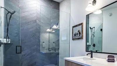 a bathroom with a glass shower and a sink at Aurora Luxe - Stunning Townhouse Private Hot Tub in Canmore