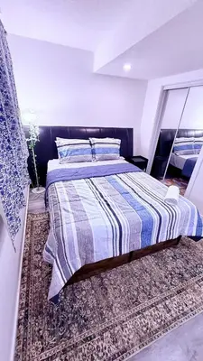 a bedroom with a bed with a striped comforter at Modern Comfort Stay Near Airport in Edmonton