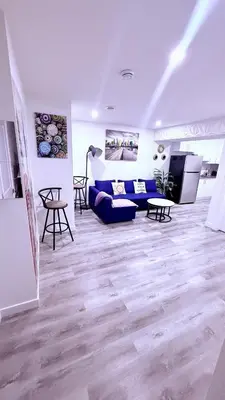 a living room with a blue couch and a tv at Modern Comfort Stay Near Airport in Edmonton