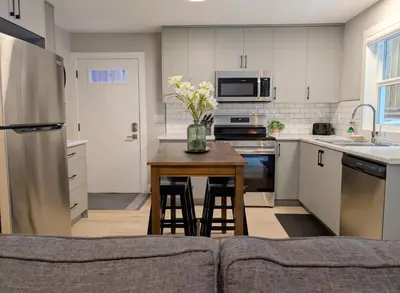 a kitchen with a table with a vase of flowers on it at Oakview Hideaway in Victoria