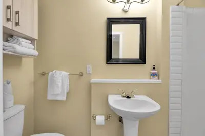 a bathroom with a sink and a mirror and a toilet at banff woods lodge in Canmore