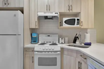 a kitchen with a white stove and a microwave at banff woods lodge in Canmore