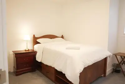 a bedroom with a bed with white sheets and a lamp at 5003R New Luxury Walkout Suite Near Calgary University in Calgary