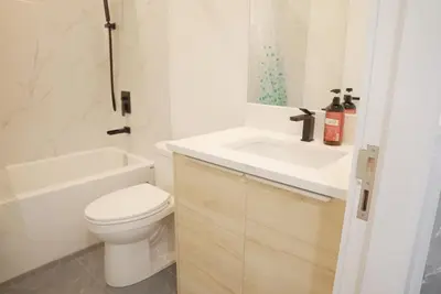 a white bathroom with a toilet and a sink at 5003R New Luxury Walkout Suite Near Calgary University in Calgary