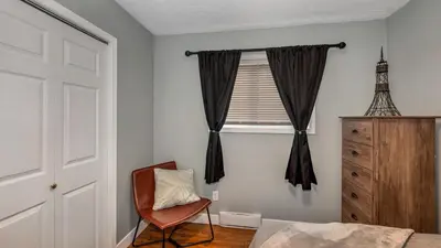 a bedroom with a bed and a chair and a window at Knockan Hill Rentals - Ground Floor Suite in Victoria