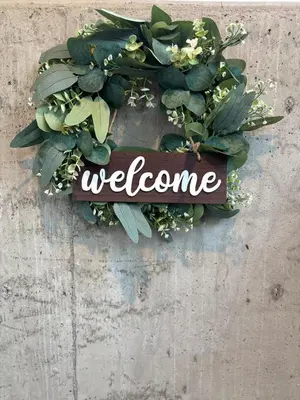 a wreath with a welcome sign on a wall at Cowichan Valley Retreat with Sauna & Free EV Charger in Duncan