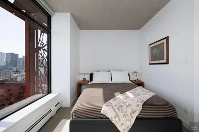 a bedroom with a bed and a large window at Spacious 2BD in Vancouver Patio with Ocean View in Vancouver