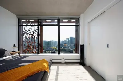 a bedroom with a bed and a large window at Spacious 2BD in Vancouver Patio with Ocean View in Vancouver