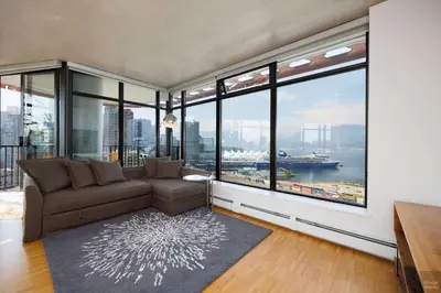 a living room with a couch and large windows at Spacious 2BD in Vancouver Patio with Ocean View in Vancouver
