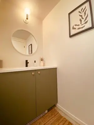 a bathroom with a green cabinet and a mirror at Fern's Edge in Port Renfrew