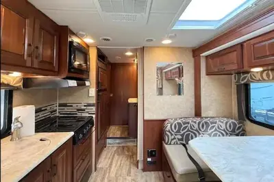 an rv kitchen with a sink and a stove at Prairie Junction Resort - Furnished RV Apartments in Stettler