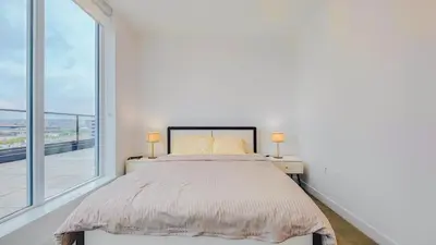 a bedroom with a bed and a large window at Modern High-Rise Condo with Stunning Garden Views in Richmond