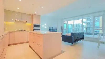 a kitchen with a counter and a couch in a room at Modern High-Rise Condo with Stunning Garden Views in Richmond