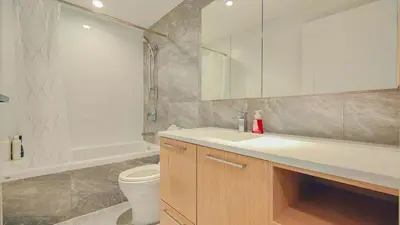a bathroom with a sink and a toilet and a tub at Modern High-Rise Condo with Stunning Garden Views in Richmond