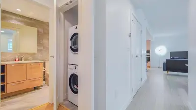 a kitchen with a washer and dryer in a room at Modern High-Rise Condo with Stunning Garden Views in Richmond
