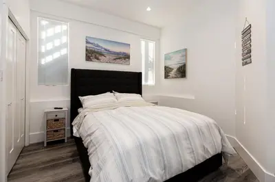 a bedroom with a bed and two windows at Sidney Solace 1BR Suite Minutes from Waterfront in Sidney