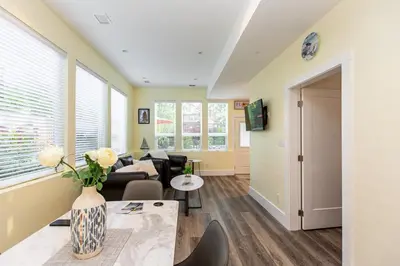 a living room with a vase of flowers on a table at Sidney Solace 1BR Suite Minutes from Waterfront in Sidney