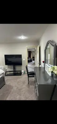a living room with a flat screen tv and a couch at Coastal Comforts Villa in Airdrie