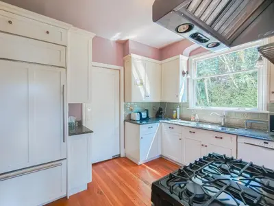 a kitchen with white cabinets and a stove top oven at Cozy Private Bedroom Suite in UBC Campus in Vancouver