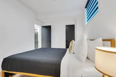 a bedroom with a bed with white sheets and pillows at The Olaf in Trendy Killarney - Close to Everything in Calgary