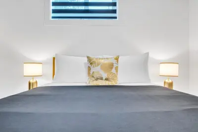 a bedroom with a bed with two lamps on it at The Olaf in Trendy Killarney - Close to Everything in Calgary