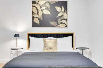 a bedroom with a bed and two side tables at The Olaf in Trendy Killarney - Close to Everything in Calgary