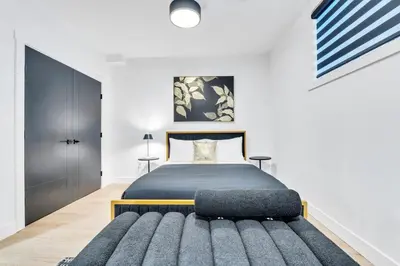 a bedroom with a king sized bed and a rug at The Olaf in Trendy Killarney - Close to Everything in Calgary