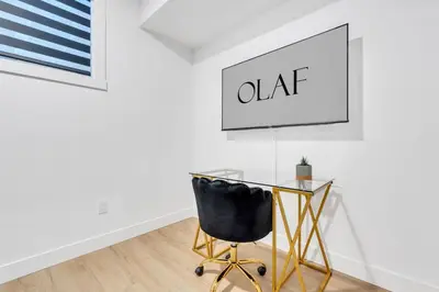 a glass table and a chair in a room at The Olaf in Trendy Killarney - Close to Everything in Calgary