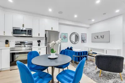 a kitchen and dining room with blue chairs and a table at The Olaf in Trendy Killarney - Close to Everything in Calgary