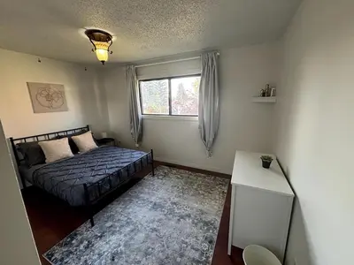 a bedroom with a bed and a window at Falcon Escape in Calgary