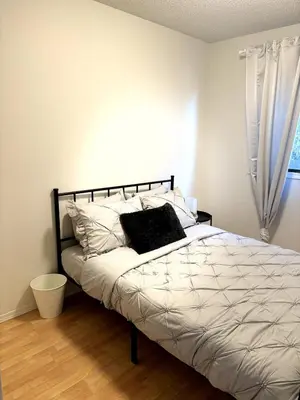 a bedroom with a bed with a pillow and a window at Falcon Escape in Calgary