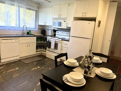 a kitchen with a table and a white refrigerator at Falcon Escape in Calgary