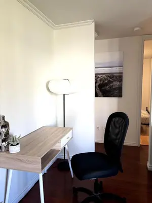 a desk with a chair and a lamp in a room at Falcon Escape in Calgary